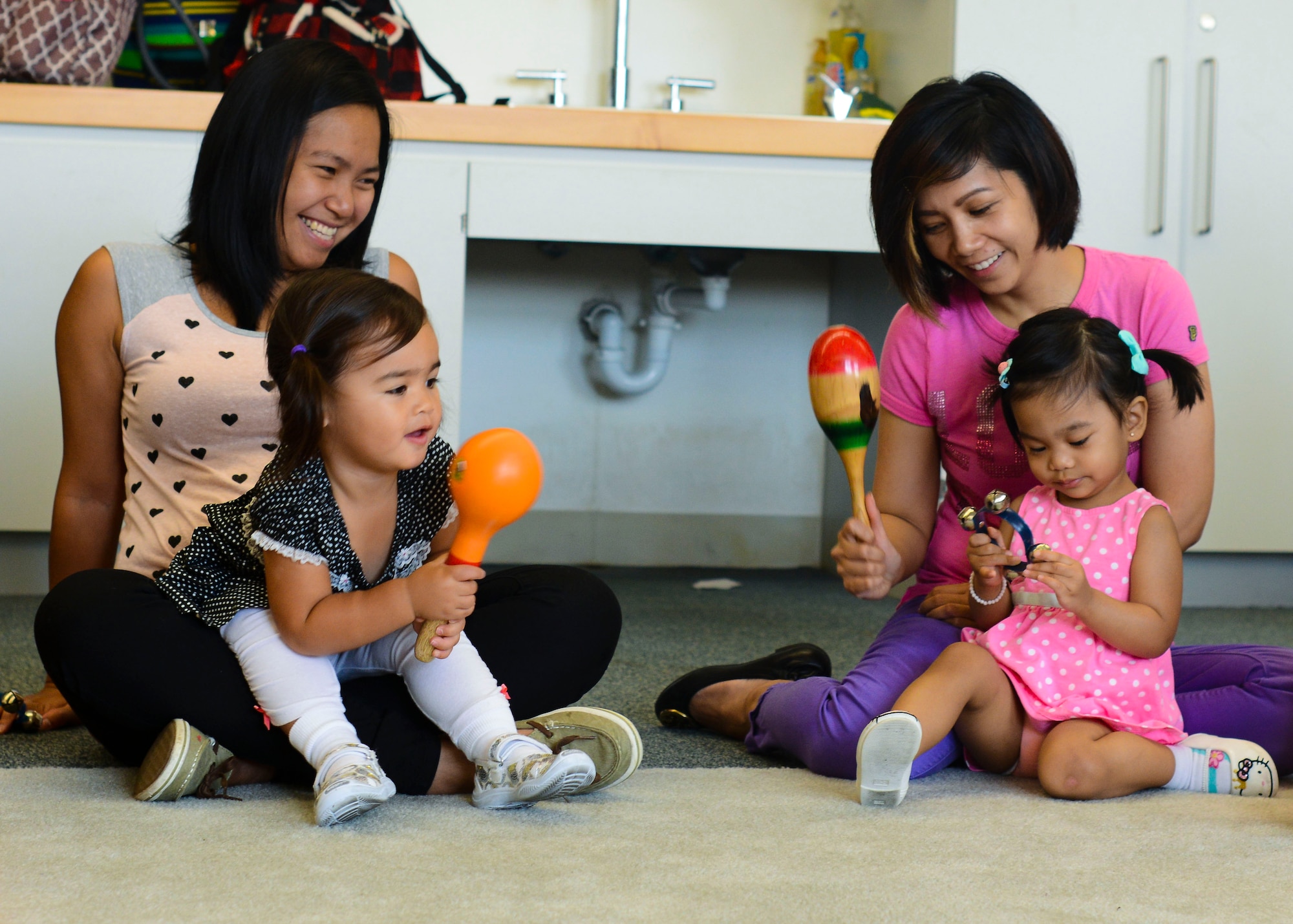 Parents and their children play musical instruments during JAM Summer Camp, July 14, 2015, at Aviano Air Base, Italy. The class included different exercises to help broaden children’s attention spans. (U.S. Air Force photo by Senior Airman Austin Harvill/Released)