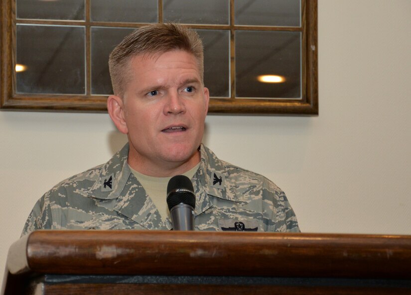 U.S. Air Force Col. Thomas D. Torkelson, 100th Air Refueling Wing commander, speaks to Team Mildenhall members during a lunch with a prisoner of war July 8, 2015, in the Galaxy Club on RAF Mildenhall, England. Following a speech and question and answer session with U.S. Air Force retired Maj. Spike Nasmyth, Torkelson coined the Vietnam War veteran. (U.S. Air Force photo by Gina Randall/Released)
