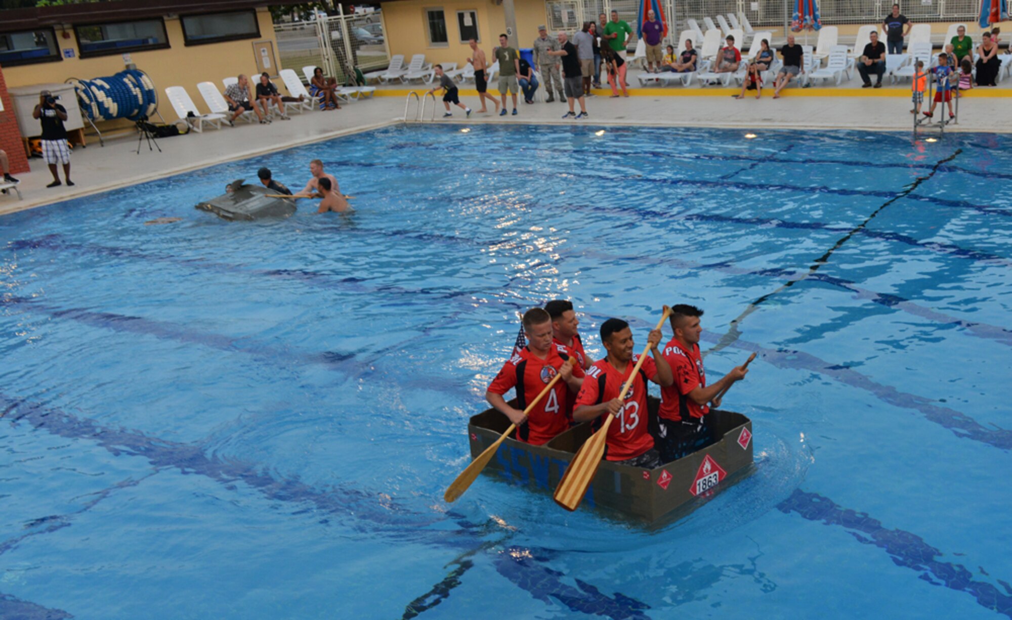 Participants of the 2nd Annual Cardboard Cup Race paddle across the base pool July 10, 2015, at Incirlik Air Base, Turkey. Teams constructed boats made of cardboard and duct tape to race each other to the end of the pool and back. (U.S. Air Force photo by Senior Airman Michael Battles/Released)