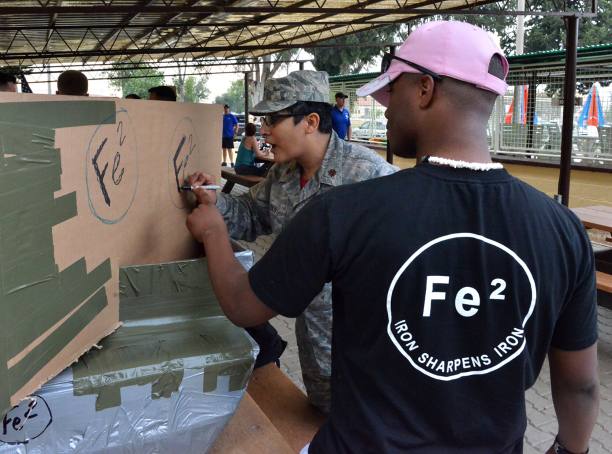 Maj. Eusebia Rios, 39th Air Base Wing deputy chaplain, decorates the FE2 cardboard boat during the 2nd Annual Cardboard Cup Race July 10, 2015, at Incirlik Air Base, Turkey. Units from across the base designed, built and raced boats made from cardboard and duct tape. (U.S. Air Force photo by Senior Airman Michael Battles/Released)