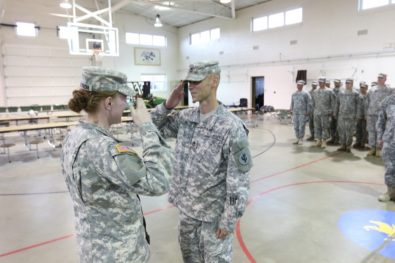 Cadet Maggie Walstrom, left, takes charge of the 353rd Transportation Company formation after convoy operations July 11, 2015. Walstrom, an Army private with the 353rd and an ROTC cadet at Minnesota State University at Mankato, is serving as a platoon leader during the unit's convoy operation. U.S. Army photo by Sgt. Victor Ayala
