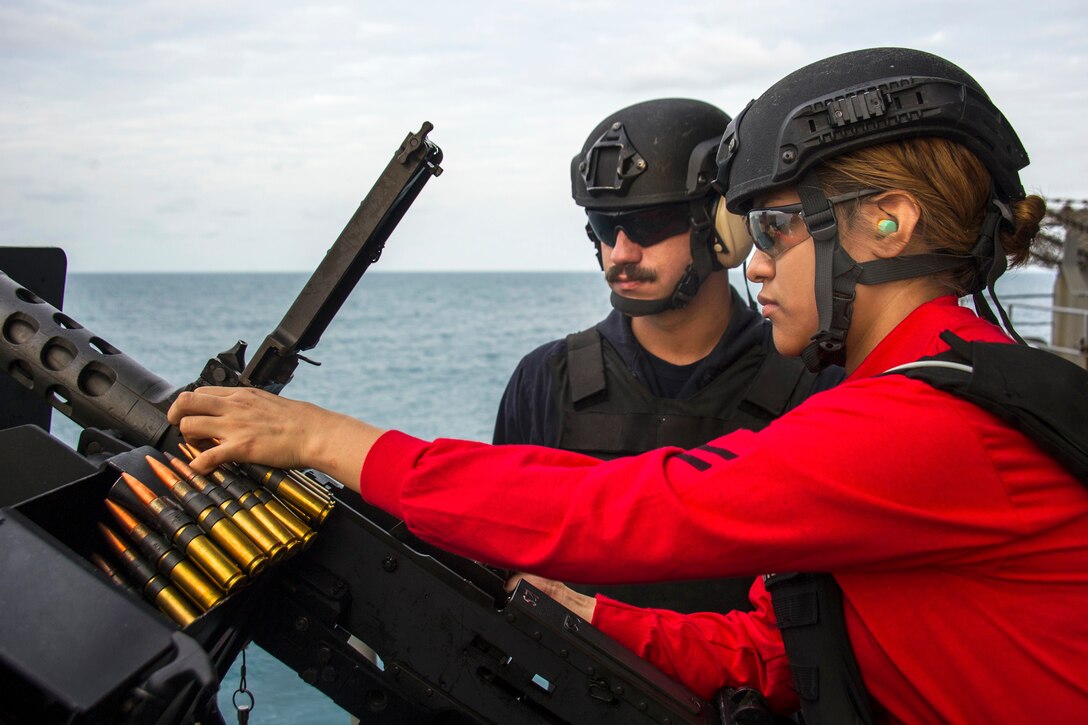 U.S. Navy Petty Officer 2nd Class Angelica Abundez, right, loads a .50-caliber machine gun during a live-fire exercise on the fantail of the USS George Washington during operations in the Timor Sea for exercise Talisman Sabre 2015, July 10, 2015. Abundez is an aviation ordnanceman.