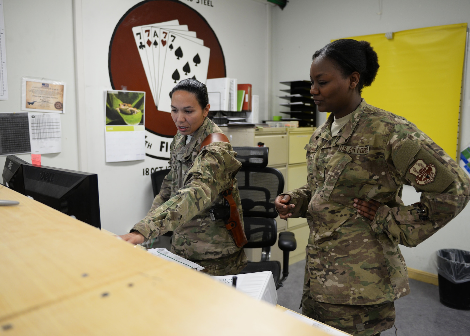 U.S. Air Force Staff Sgt. Elizabeth Velez, left, and Airman 1st Class Bryana Brown, 555th Expeditionary Fighter Squadron aviation resource managers, conduct a shift change July 15, 2015, at Bagram Airfield, Afghanistan. The Airmen are both a part of the Squadron Aviation Resource Management team which is responsible for managing F-16 pilots flying currencies as well as maintaining communication between the pilots and the operations and maintenance squadrons. (U.S. Air Force photo by Senior Airman Cierra Presentado/Released)