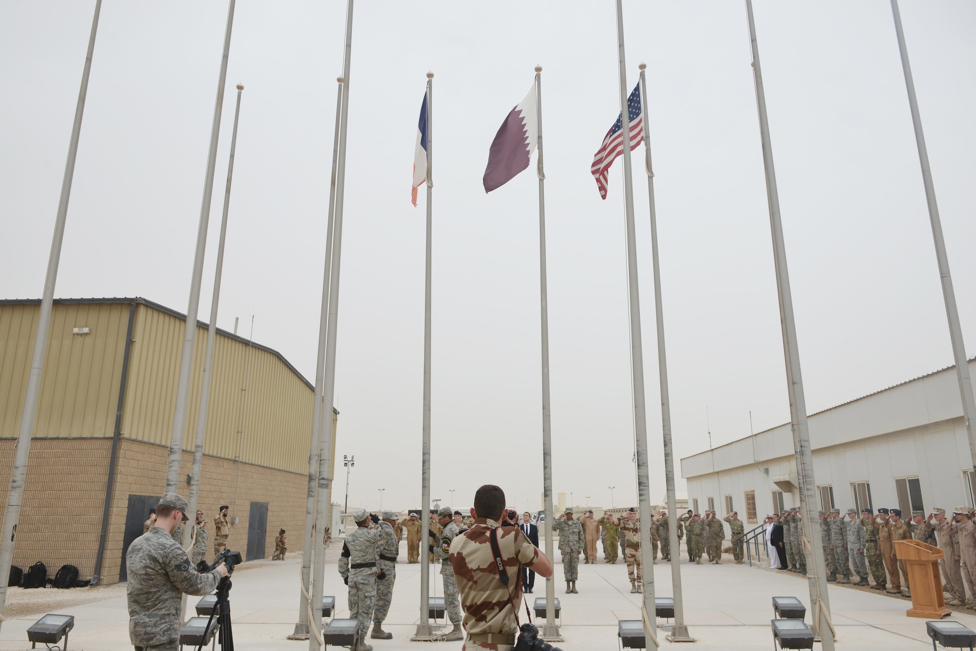 Broadcasters and Photojournalists from the 379th Air Expeditionary Wing and French Combined Air Operations Center document the beginning of the Bastille Day ceremony July 14, 2015 at Al Udeid Air Base, Qatar. The French celebrate July 14th as Bastille Day to commemorate the storming of Bastille at the beginning of the French revolution in 1789. (U.S. Air Force photo/Staff Sgt. Alexandre Montes)
