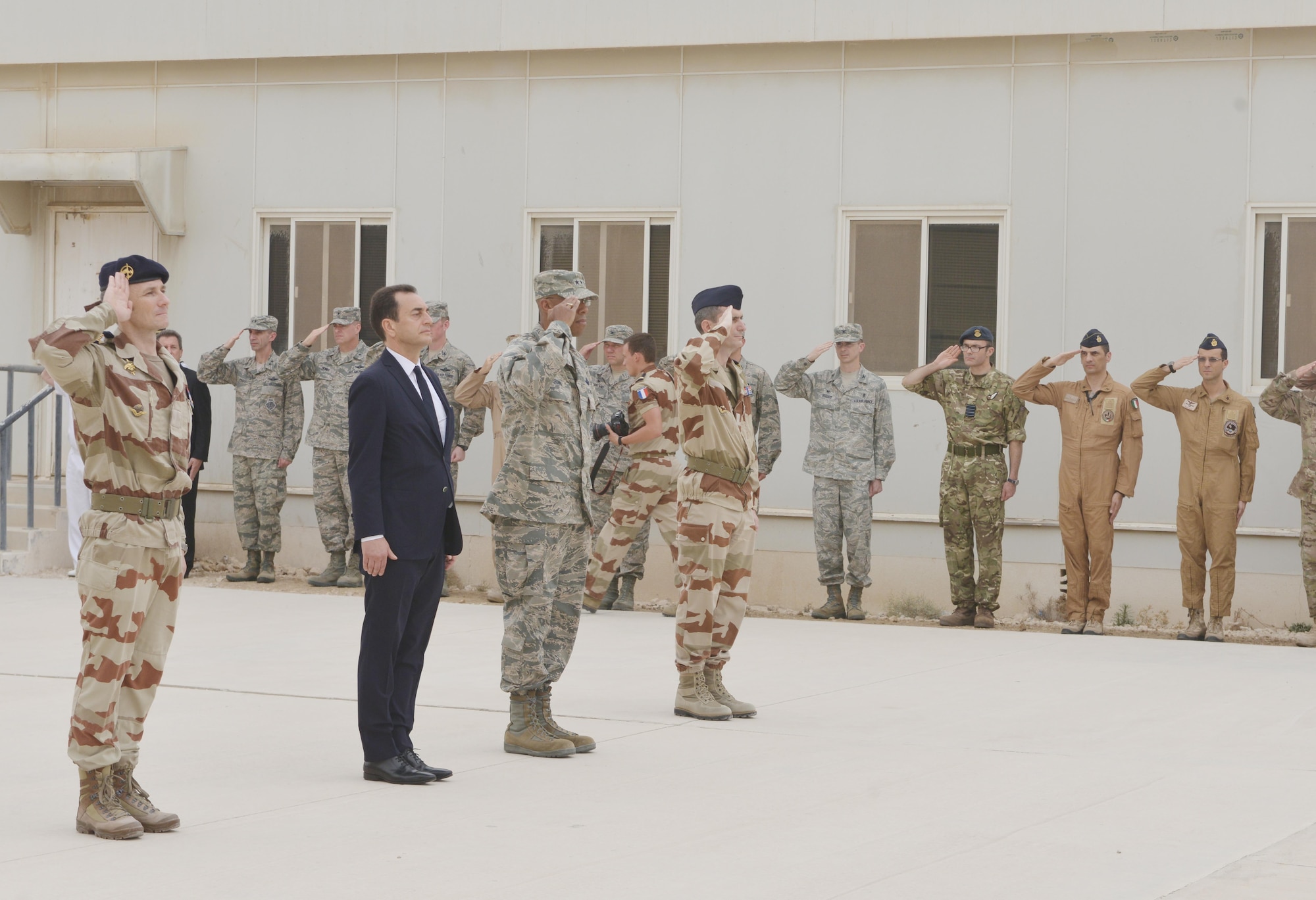 Distinguished visitors render a salute during the playing of the French national anthem during the Bastille Day ceremony July 14, 2015 at Al Udeid Air Base, Qatar. The French celebrate July 14th As Bastille Day to commemorate the storming of Bastille at the beginning of the French revolution in 1789. (U.S. Air Force photo/Staff Sgt. Alexandre Montes)