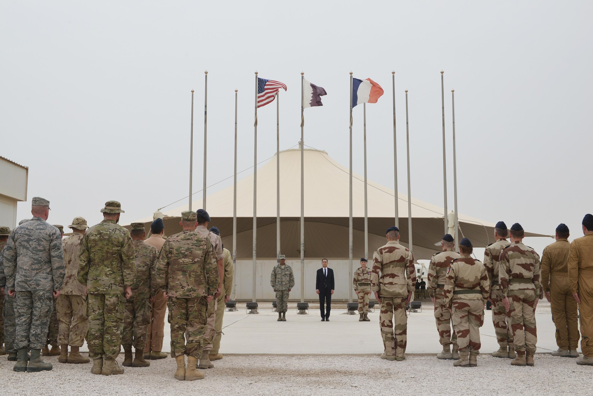 Coalition Forces commanders and Combined Air Operations Center members stand at attention while the French national anthem plays during the Bastille Day ceremony July 14, 2015 at Al Udeid Air Base, Qatar. The French celebrate July 14th as Bastille Day to commemorate the storming of Bastille at the beginning of the French revolution in 1789. (U.S. Air Force photo/Staff Sgt. Alexandre Montes)