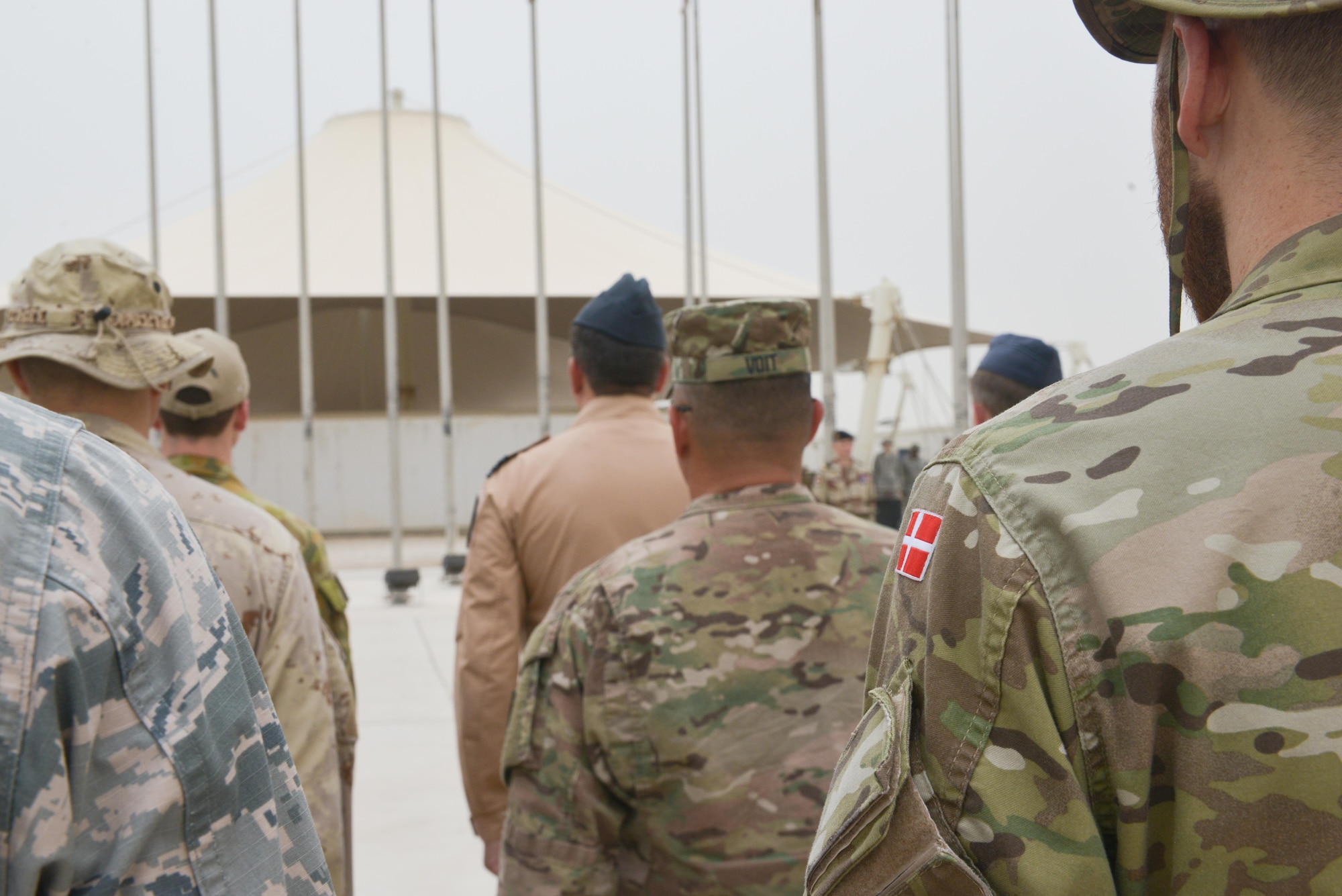 Combined Air Operations Center members stand in formation during the Bastille Day ceremony July 14, 2015 at Al Udeid Air Base, Qatar. The French celebrate July 14th as Bastille Day to commemorate the storming of Bastille at the beginning of the French revolution in 1789. (U.S. Air Force photo/Staff Sgt. Alexandre Montes)