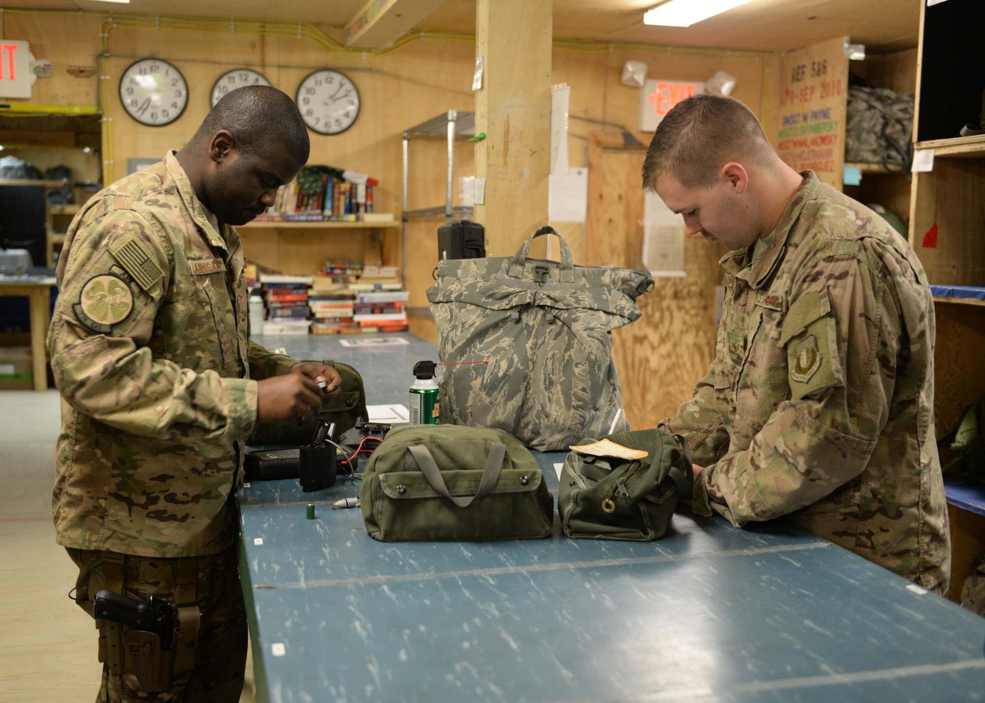 U.S. Air Force Senior Airman Greg Flannigan, 455th Expeditionary Airlift Squadron aircrew flight equipment journeyman, issues lifesaving equipment to a C-130 aircrew member July 17, 2015 at Bagram Airfield Afghanistan. Flannigan is responsible for making sure aircrews are supplied with lifesaving equipment prior to flying a mission here. (U.S. Air Force photo by Senior Airman Cierra Presentado/Released)