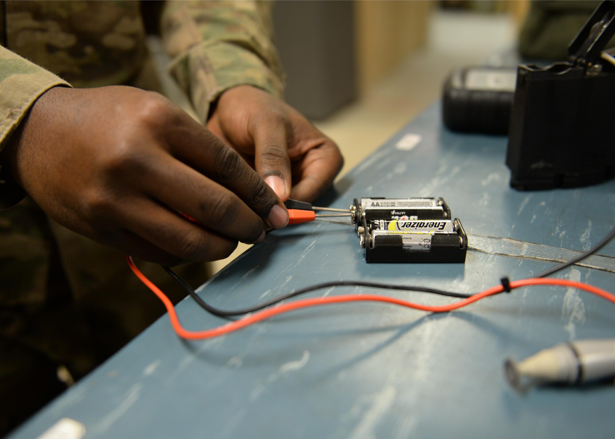 U.S. Air Force Senior Airman Greg Flannigan, 455th Expeditionary Airlift Squadron aircrew flight equipment journeyman, charges a battery before placing them in a radio that is apart of the lifesaving equipment issued to C-130 aircrew prior to flying a mission July 17, 2015 at Bagram Airfield, Afghanistan. Flannigan is responsible for making sure aircrews are supplied with lifesaving equipment prior to flying a mission here. (U.S. Air Force photo by Senior Airman Cierra Presentado/Released)