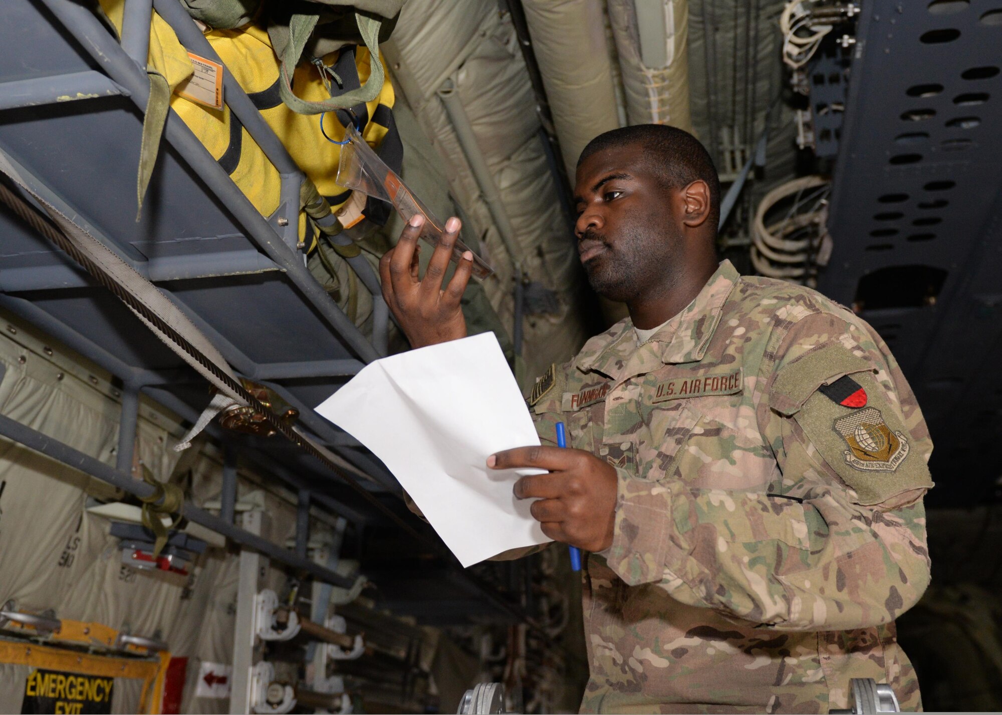 U.S. Air Force Senior Airman Greg Flannigan, 455th Expeditionary Airlift Squadron aircrew flight equipment journeyman, inspects aircrew flight equipment July 17, 2015, at Bagram Airfield, Afghanistan. Flannigan is responsible for making sure C-130 aircrews are supplied with lifesaving equipment prior to flying a mission here. (U.S. Air Force photo by Senior Airman Cierra Presentado/Released)