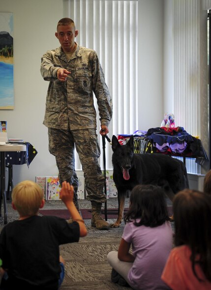 Staff Sgt. Ryan Troester, 1st Special Operations Security Forces Squadron military working dog trainer, receives questions from children at the Mary Esther public library, July 15, 2015, in Mary Esther, Fla. The library hosted a Military Animal Heroes event as part of their Summer Reading Program and Hurlburt Field’s K9 unit was invited to come speak about their profession.  (U.S. Air Force photo/Senior Airman Meagan Schutter)