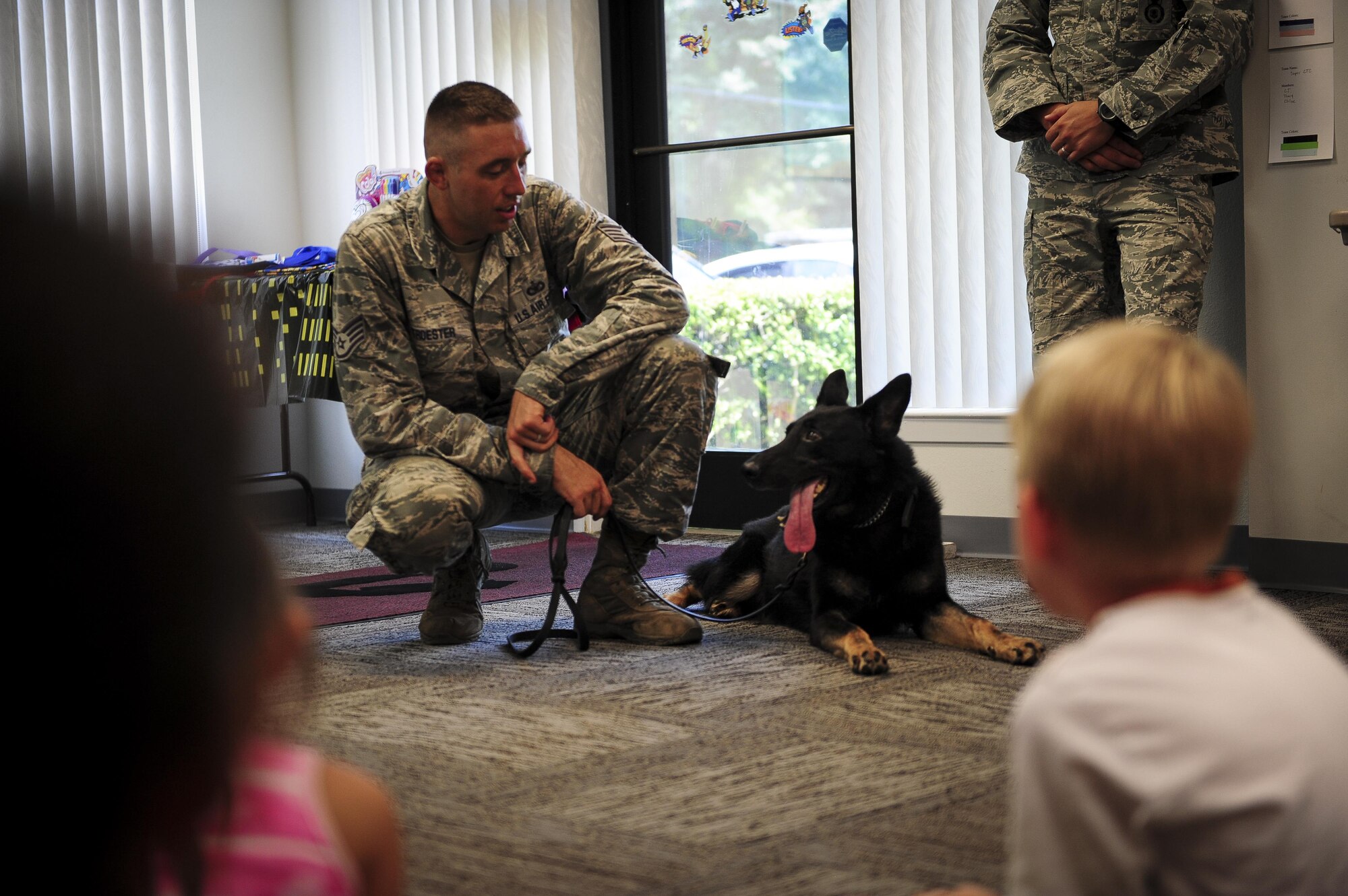 Staff Sgt. Ryan Troester, 1st Special Operations Security Forces Squadron military working dog trainer, speaks to children about Cleo, a military working dog, July 15, 2015, in Mary Esther, Fla. The library hosted a Military Animal Heroes event as part of their Summer Reading Program and Hurlburt Field’s K9 unit was invited to come speak about their profession.  (U.S. Air Force photo/Senior Airman Meagan Schutter)
