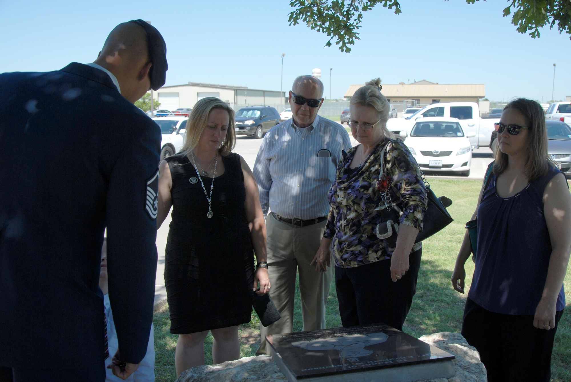 U.S. Air Force Master Sgt. Russell Weatherby, 17th Security Forces Squadron individual mobilization augmentee, shows the family of Tech. Sgt. Christopher Kelley, 17th SFS IMA, the Airman 1st Class Elizabeth Jacobson memorial in front of the 17th SFS building on Goodfellow Air Force Base, Texas, July 16, 2015. Kelley and Jacobson are both security forces airmen who lost their lives in the line of duty. (U.S. Air Force photo by Senior Airman Joshua Edwards/Released)