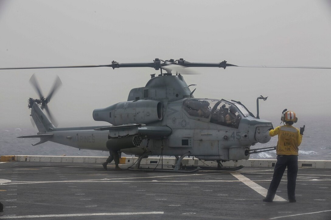 ARABIAN SEA (July 14, 2015) U.S. Navy Petty Officer 2nd Class Samina Henry gives a start rotor signal to an AH-1Z Viper with the “Greyhawks” of Marine Medium Tiltrotor Squadron 161 (Reinforced), 15th Marine Expeditionary Unit, on the flight deck of the amphibious transport dock ship USS Anchorage (LPD 23). The “Greyhawks” are the aviation combat element of the 15th MEU, and embarked aboard the ships of the Essex Amphibious Ready Group, are deployed in support of maritime security operations and theater security cooperation efforts in the U.S. 5th Fleet area of operations. (U.S. Marine Corps photo by Sgt. Jamean Berry/ Released)