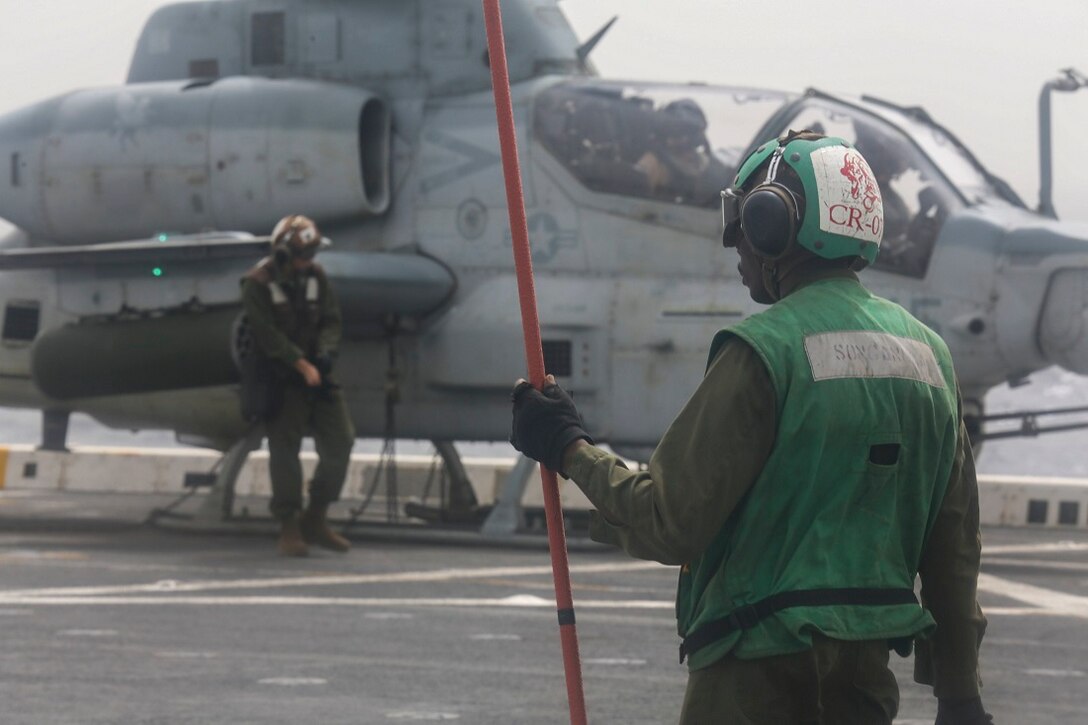 ARABIAN SEA (July 14, 2015) U.S. Marine Cpl. Zion Songonuga stands fire guard on the flight deck of the amphibious transport dock ship USS Anchorage (LPD 23). Songonuga is an airframes mechanic with the “Greyhawks” of Marine Medium Tiltrotor Squadron 161 (Reinforced), 15th Marine Expeditionary Unit. The “Greyhawks” are the aviation combat element of the 15th MEU, and embarked aboard the ships of the Essex Amphibious Ready Group, are deployed in support of maritime security operations and theater security cooperation efforts in the U.S. 5th Fleet area of operations. (U.S. Marine Corps photo by Sgt. Jamean Berry/ Released)