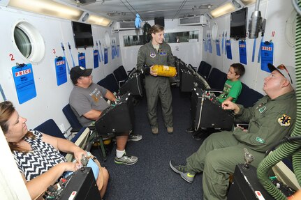 Maj. Jennifer Giovannetti, 359th Aerospace Medicine Squadron night vision goggle academic instructor course and aerospace and operational physiology flight commander, speaks to Jared Stadler, 560 th Flying Training Squadron pilot for a day, and his family in an altitude chamber July 17, 2015, at Joint Base San Antonio-Randolph. As part of being pilot for a day, Stadler was given a flight suit and patches and spent the day learning what it’s like to be an Air Force pilot. (U.S. Air Force photo by Melissa Peterson/Released)