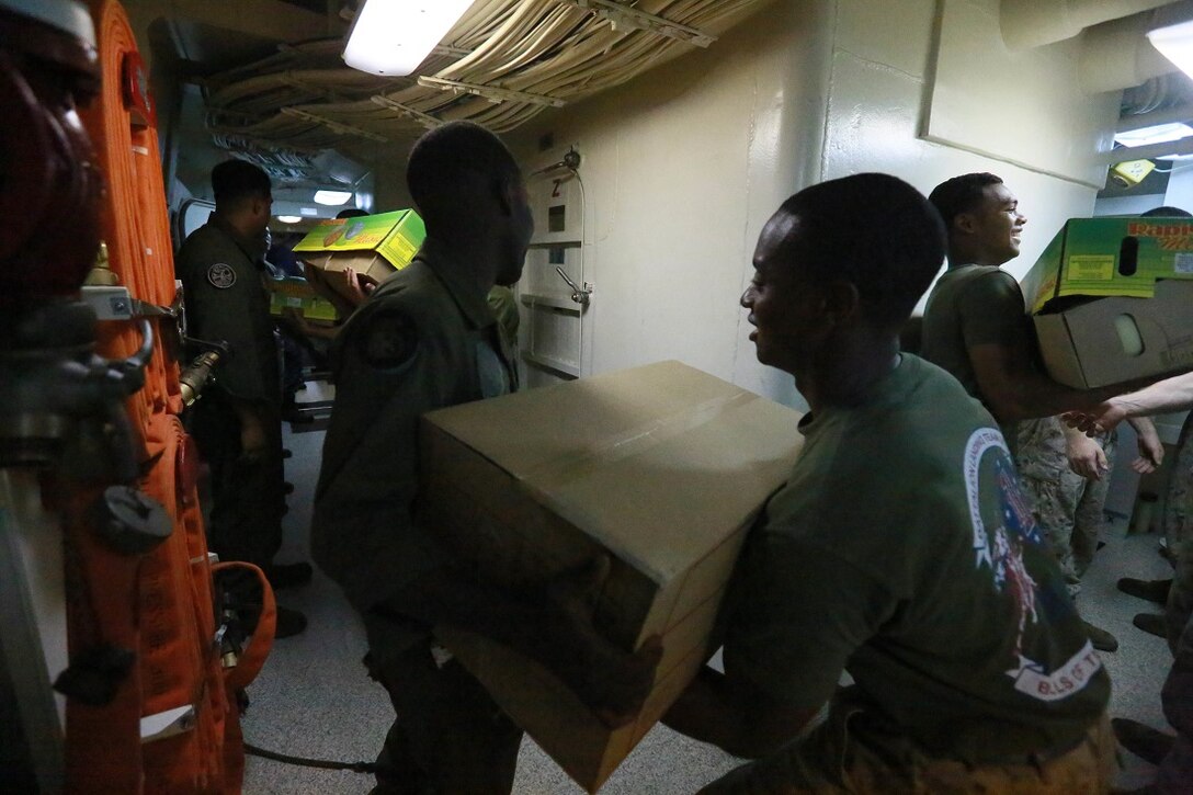 Marines and Sailors of the 15th Marine Expeditionary Unit and Essex Amphibious Ready Group carry boxes inside the ship during a replenishment at sea aboard the amphibious transport dock ship USS Anchorage (LPD 23). The Marines of the 15th MEU are embarked aboard the Anchorage, which is part of the Essex ARG, and are deployed in support of maritime security operations and theater security cooperation efforts in the U.S. 5th Fleet area of operations. (U.S. Marine Corps photo by Sgt. Steve H. Lopez/ Released)