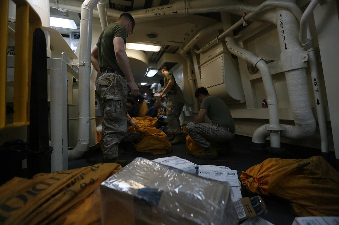 Marines and Sailors of the 15th Marine Expeditionary Unit and Essex Amphibious Ready Group sort mail aboard the amphibious transport dock ship USS Anchorage (LPD 23). The Marines of the 15th MEU are embarked aboard the Anchorage, which is part of the Essex ARG, and are deployed in support of maritime security operations and theater security cooperation efforts in the U.S. 5th Fleet area of operations. (U.S. Marine Corps photo by Sgt. Steve H. Lopez/ Released)