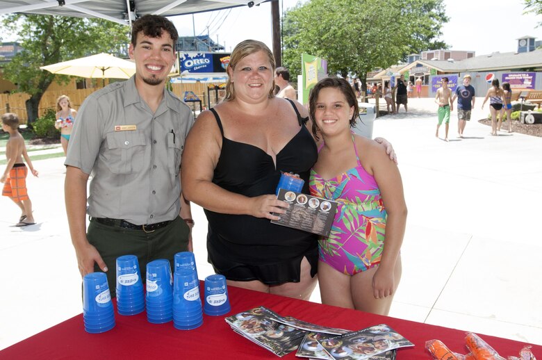 J. Percy Priest Lake Park Ranger Adam Johnson poses with a mother and daughter while he handed out water safety goodies and provided information at Nashville Shores Lakeside Resort July 10, 2015.  The Corps is setting up a booth every Friday from noon to 2 p.m. to pass out water safety goodies and to talk with families about wearing life jackets when recreating at the park and lake.