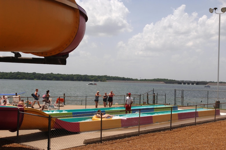 People exit a water slide at Nashville Shores Lakeside Resort July 10, 2015 with J. Percy Priest Dam in the background.  The U.S. Army Corps of Engineers Nashville District’s park rangers at J. Percy Priest Lake are partnering with Nashville Shores Lakeside Resort this summer to promote water safety.  The Corps is setting up a booth every Friday from noon to 2 p.m. to pass out water safety goodies and to talk with families about wearing life jackets when recreating at the park and lake.