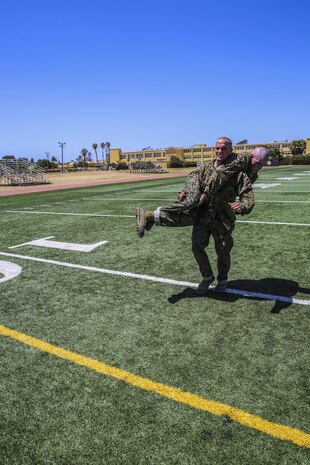 Recruit Bryson Hatch, Alpha Company, 1st Recruit Training Battalion, preforms a fireman’s carry during the Initial Combat Fitness Test at Marine Corps Recruit Depot San Diego, July 15. The maneuver under fire portion of the test is a course that covers 75 yards, which requires recruits to perform exercises such as sprints, ammunition can carries, fireman’s carry and throwing a simulated grenade at a marked target. Recruits were timed as they ran through the course and needed to finish it in less than 2 minutes and 14 seconds to receive 100 points. Hatch is a native of Burlington, Kan., and was recruited out of Recruiting Station Kansas City. Today, all males recruited from west of the Mississippi are trained at MCRD San Diego. The depot is responsible for training more than 16,000 recruits annually. Kilo Company is scheduled to graduate Sept. 18.