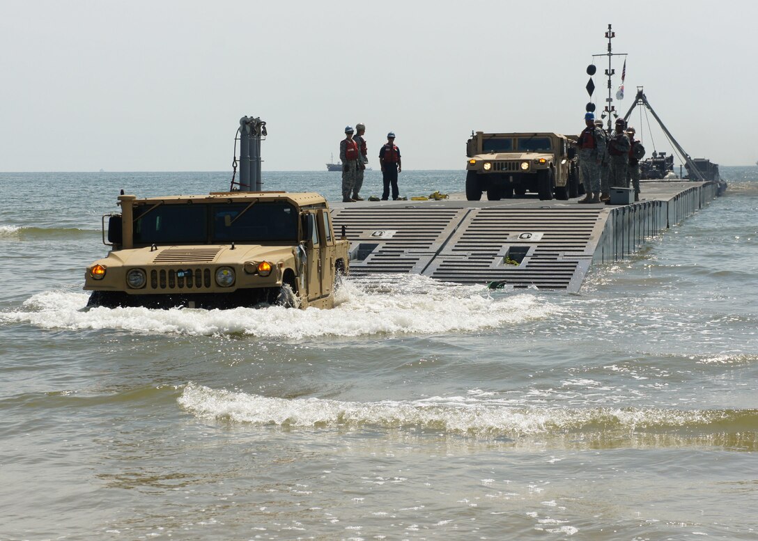 ANMYEON BEACH, Republic of Korea (July 3, 2015) – U.S. Marines from the 3rd Marine Expeditionary Force drive High Mobility Multipurpose Wheeled Vehicles (HMMWV) to the beach from a Causeway ferry operated by the 331st Transportation Company at Anmyeon Beach on the west coast of the Republic of Korea during exercise Combined Joint Logistics Over-the-Shore (LOTS) 2015.  CJLOTS 2015 is an exercise designed to train U.S. and ROK service members to accomplish vital logistical measures in a strategic area while strengthening communication and cooperation in the U.S.-ROK Alliance.  (U.S. Navy Photo by LT Russell Wolfkiel/Released)