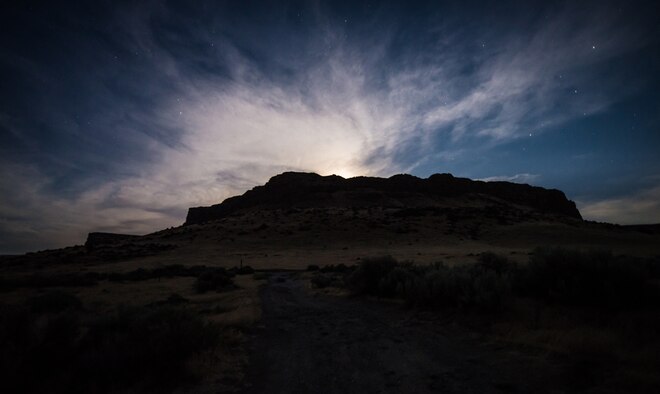 The moon illuminates the sky as it peaks over a bluff July 1, 2015, at Crane Falls, Idaho. Crane Falls offers camping areas, boat launches and two bodies of water for anglers and boaters to enjoy all year. (U.S. Air Force photo by Airman 1st Class Connor J. Marth)