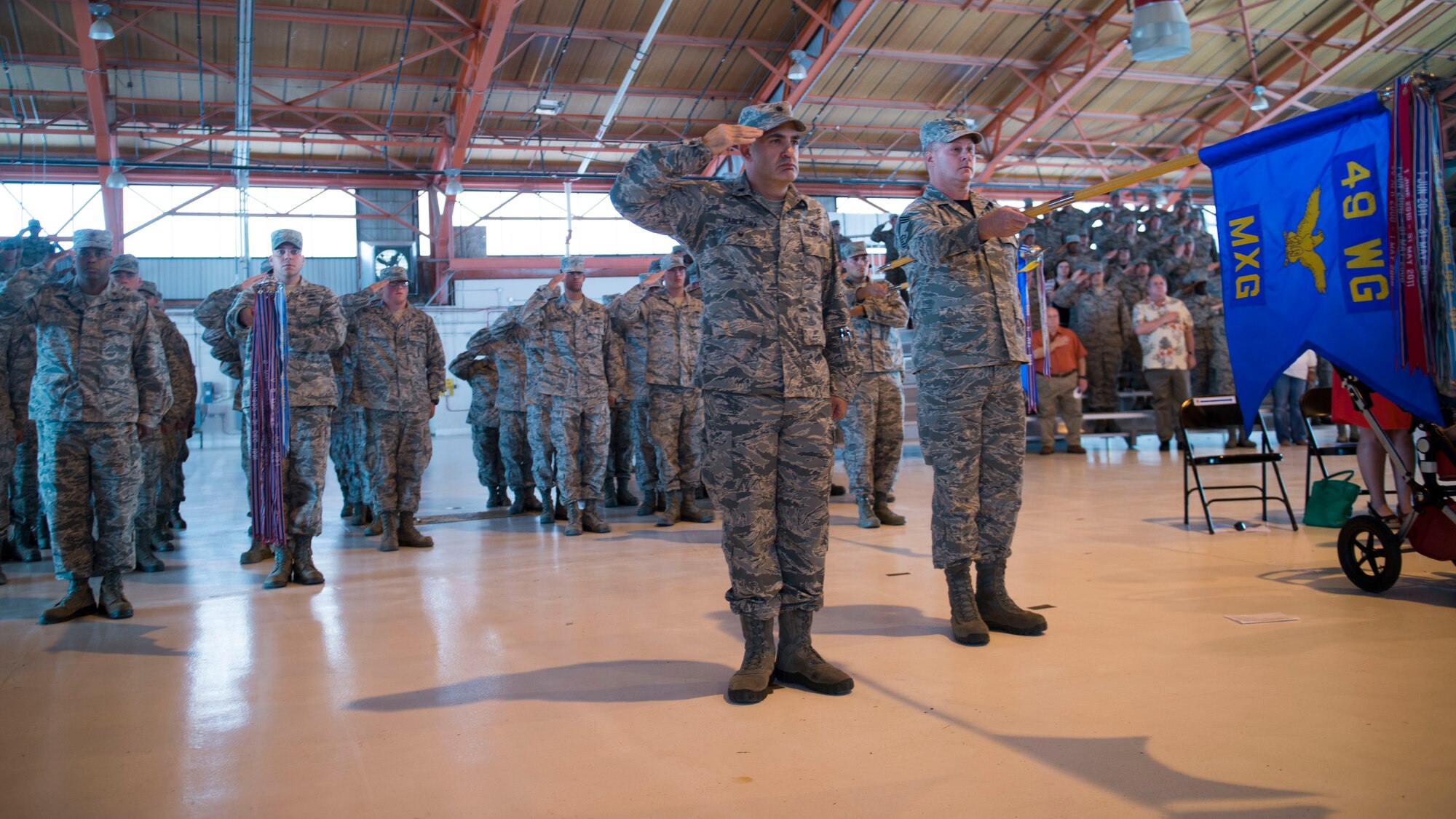 The 49th Maintenance Group squadrons present arms during the singing of the Star Spangled Banner during the groups Change of Command at Holloman Air Force Base, N.M., July 17, 2015. During this ceremony Col. Michael Shea, the outgoing 49th Maintenance Group commander, relinquished command to Col. Lyle Drew.(U.S. Air Force photo by Senior Airman Chase Cannon)