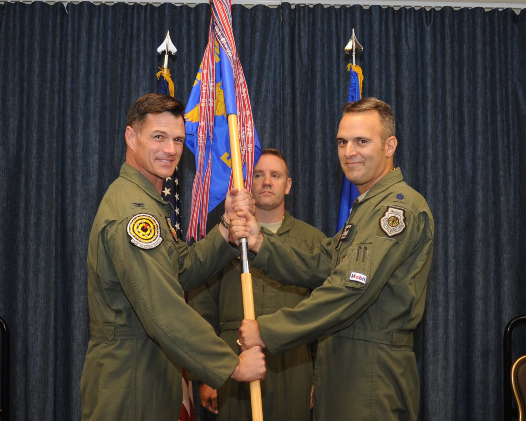 Col. Michael Drowley, U.S. Air Force Weapons School commandant, takes the 509th Weapons Squadron guidon from Lt. Col. Brian Eberling, former 509th WPS commander, during the 509th WPS change of command ceremony July 17, 2015, at Fairchild Air Force Base, Wash. The change of command ceremony is an official, formal and brief ceremony that is the military’s way of bestowing command responsibility of a unit from one officer to another. (U.S. Air Force photo/Senior Airman Sam Fogleman)