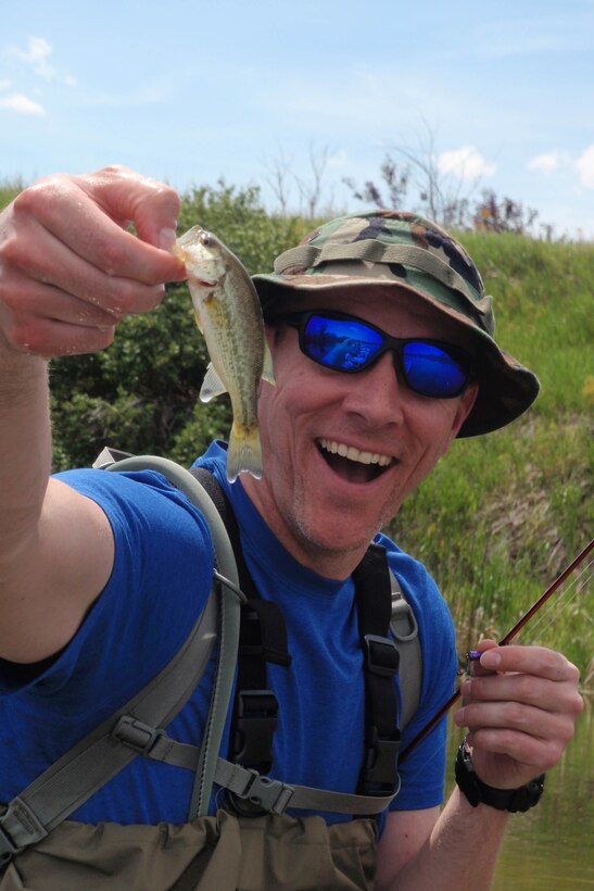 Tech. Sgt. Chad Thompson, 341st Missile Wing Public Affairs, shows off his “record” catch during a recent fishing outing to Pelican Point, June 7, 2015. This bass was caught on a spinning rod and small spinner bait. Thompson has fallen in love with the outdoors since arriving to Montana and fly fishing is just one way he relieves his stress. (Courtesy photo)