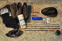 These are some of the essentials for any fly fishing trip: Waders and wading boots, a hat and pair of polarized sunglasses, Montana Fishing Guide, net, knife, sunscreen, forceps, fly box with a good variety of assorted flies, and a fly rod and reel. (U.S. Air Force photo/Tech. Sgt. Chad Thompson)