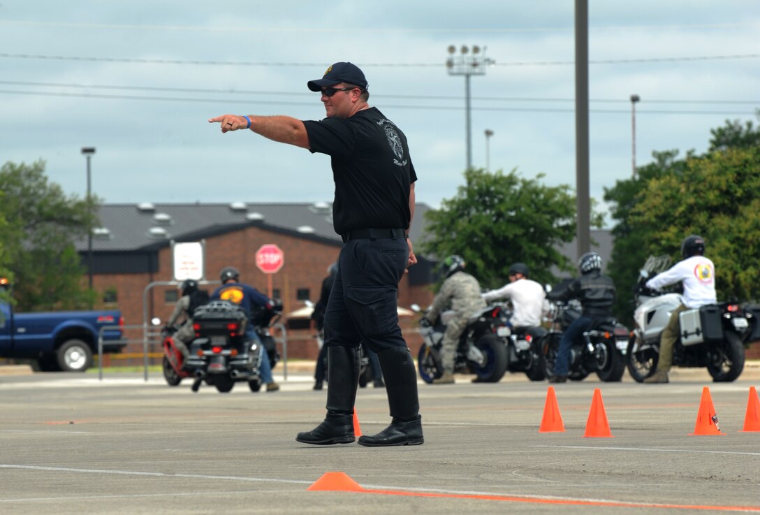 A motorcycle officer from Abilene Police Department directs riders July 1, 2015 at the Base Exchange at Dyess Air Force Base, Texas. The officer provided hands-on training in the execution of safe riding techniques to all of the participants of the Dyess Motorcycle Safety Rodeo. (U.S. Air Force photo by Airman Quay Drawdy/Released)