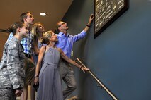 Relatives of U.S. Navy Lt. Seymour A. Johnson look at historic photos of the base with 1st Lt. Lydia Goodloe, 4th Mission Support Group executive officer, July 15, 2015, at Seymour Johnson Air Force Base, North Carolina. In addition to photos from Johnson’s career, the 4th MSG also has his original uniform on display. (U.S. Air Force photo/ Airman 1st Class Ashley Williamson)
