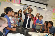 Trilisa Garrett, DoD STARBASE-Kelly instructor, shows students how to pack a model rocket’s parachute during one of the summer sessions given by DoD STARBASE-Kelly, Joint Base San Antonio-Lackland, Texas on July 17, 2015. All 20 students successfully launched their rockets later that morning. (U.S. Air Force photo/Tech. Sgt. Carlos J. Trevino)