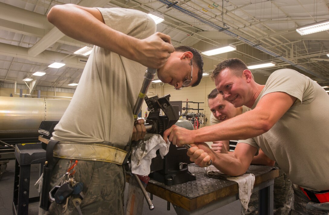 U.S. Air Force Senior Airmen Adam Michaud, left, and David Lee, 23d Equipment Maintenance Squadron combat armament system team members, and Staff Sgt. Chad Ufholz, 23d EMS weapons armament system craftsman, fix a 30mm GAU-8/A gatling gun ammunition drum drive assembly July 11, 2015, at Moody Air Force Base, Ga. The weekend crew works eight-hour days on Mondays and Fridays and 12-hour days on Saturdays and Sundays. (U.S. Air Force photo by Airman 1st Class Ceaira Tinsley/Released)