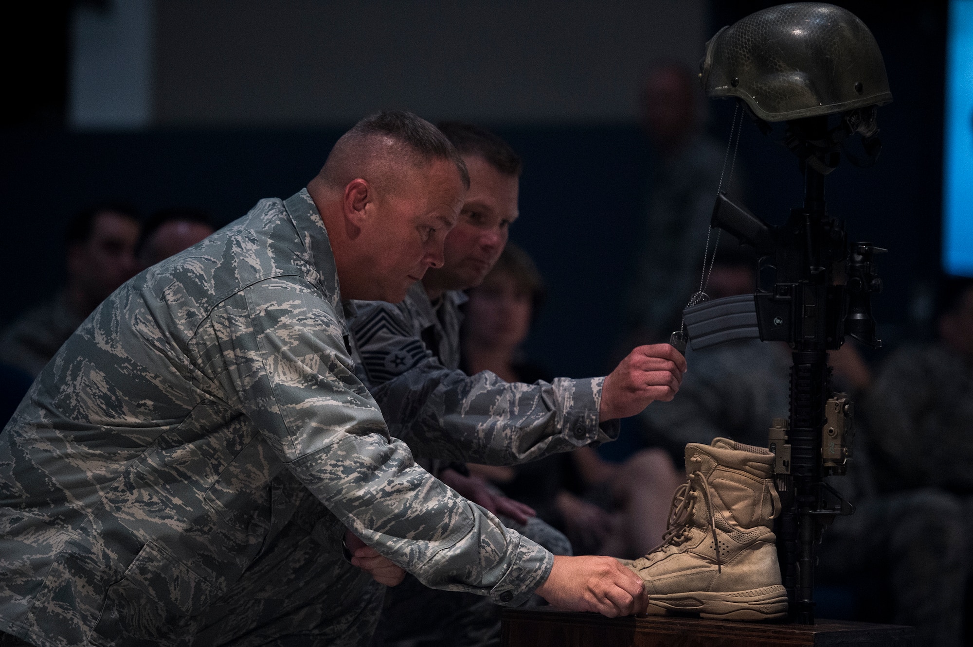 U.S. Air Force Col. Michael Ross, 820th Base Defense Group commander, and Chief Master Sgt. Artie Pearson, 820th BDG chief enlisted manager, kneel in front of a battle cross during a memorial service July 16, 2015, at Moody Air Force Base, Ga. During the service, Ross and Pearson both spoke their experiences working alongside Fulp and gave insight about his tenacity and leadership. (U.S. Air Force photo by Senior Airman Ryan Callaghan/Released)


