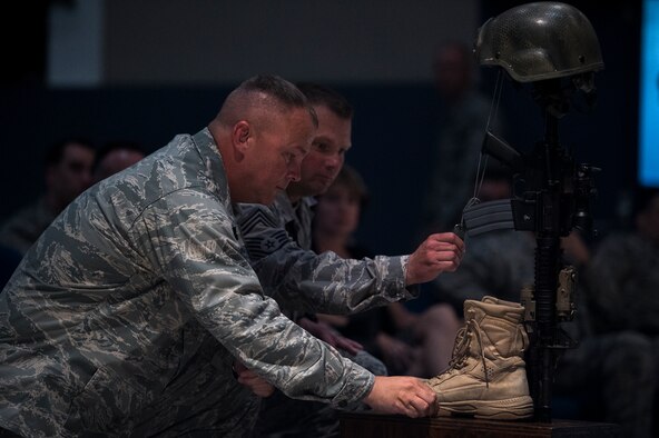 U.S. Air Force Col. Michael Ross, 820th Base Defense Group commander, and Chief Master Sgt. Artie Pearson, 820th BDG chief enlisted manager, kneel in front of a battle cross during a memorial service July 16, 2015, at Moody Air Force Base, Ga. During the service, Ross and Pearson both spoke their experiences working alongside Fulp and gave insight about his tenacity and leadership. (U.S. Air Force photo by Senior Airman Ryan Callaghan/Released)


