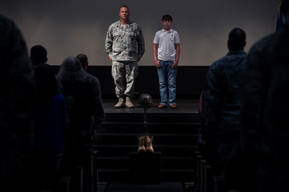 Hunter Fulp, right, son of deceased Tech. Sgt. Lee Fulp, stands next to U.S. Air Force Col. Michael Ross, 820th Base Defense Group commander, during a memorial service July 16, 2015, at Moody Air Force Base, Ga. Hunter accepted a medal, awarded posthumously, on his father’s behalf. (U.S. Air Force photo by Senior Airman Ryan Callaghan/Released)

