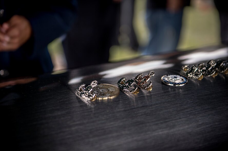 Explosive ordnance disposal badges and military challenge coins rest on top of the casket of Tech. Sgt. Lee Fulp, July 14, 2015, at the Fellowship Baptist Church in Adel, Ga. Fulp was the NCO in charge of explosive ordnance disposal at the 820th Combat Operations Squadron. (U.S. Air Force photo by Senior Airman Ryan Callaghan/Released)

