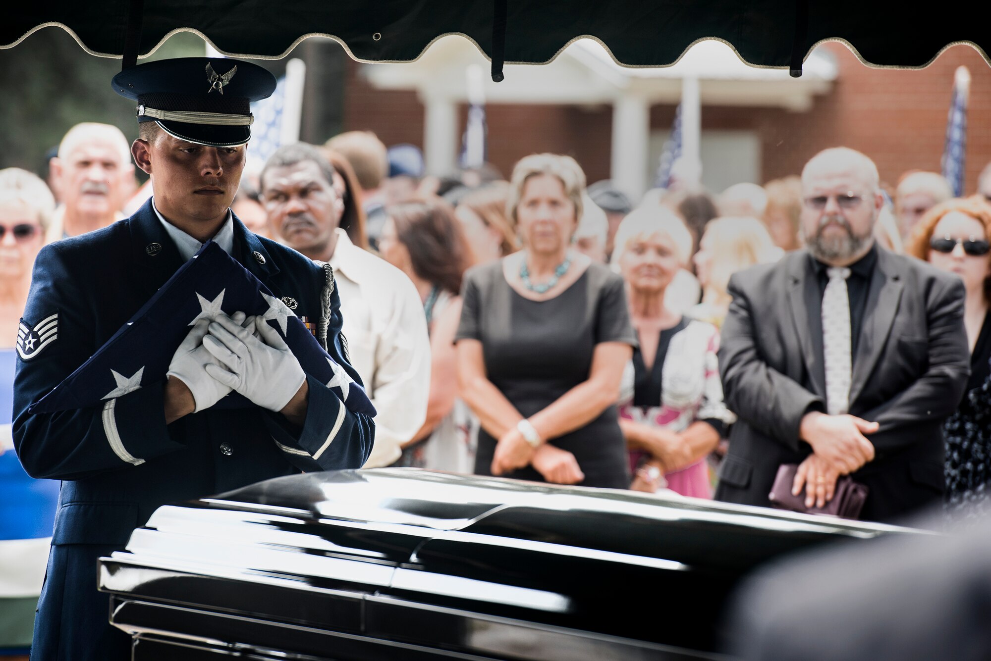 U.S. Air Force Staff Sgt. Billy Morgan, 23d Wing honor guard member, holds a folded flag over the casket of Tech. Sgt. Lee Fulp, July 14, 2015, at the Fellowship Baptist Church in Adel, Ga. Fulp passed away after a motorcycle accident July 11. (U.S. Air Force photo by Senior Airman Ryan Callaghan/Released)

