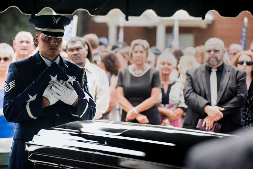 U.S. Air Force Staff Sgt. Billy Morgan, 23d Wing honor guard member, holds a folded flag over the casket of Tech. Sgt. Lee Fulp, July 14, 2015, at the Fellowship Baptist Church in Adel, Ga. Fulp passed away after a motorcycle accident July 11. (U.S. Air Force photo by Senior Airman Ryan Callaghan/Released)

