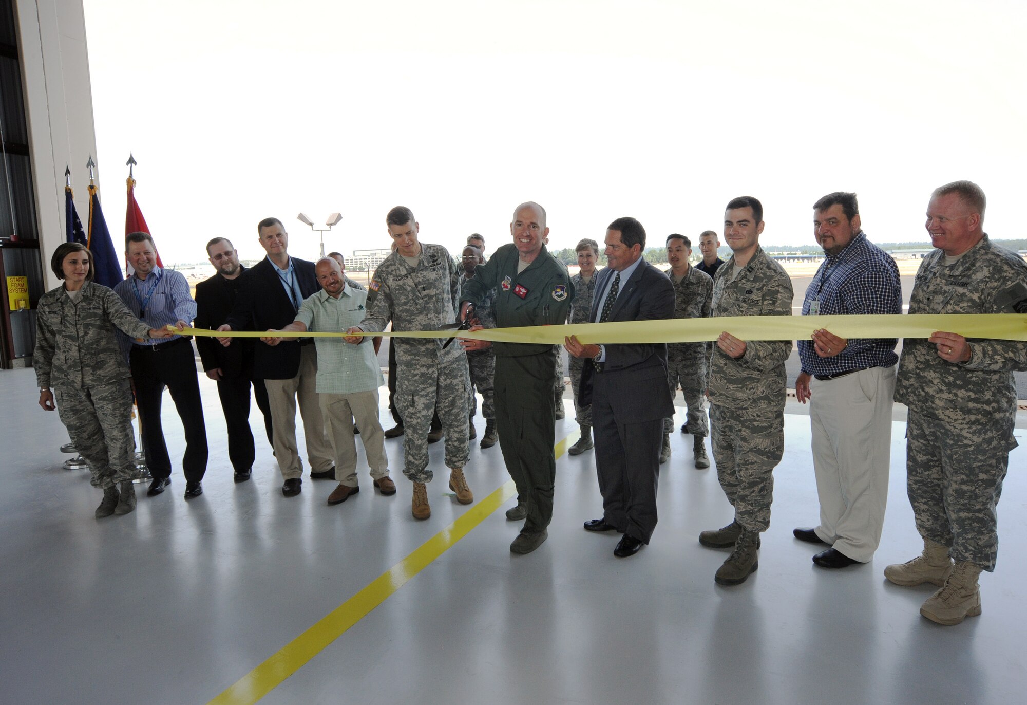 Oregon Air National Guard Col. Paul T. Fitzgerald, 142nd Fighter Wing commander, center right, and Oregon Army National Guard Maj. Gen. Daniel R. Hokanson, Adjutant General, Oregon, center left, along with other dignitaries, take part in a ribbon cutting ceremony for a new alert barn at the Portland Air National Guard Base, Ore., July 10. The new alert barn will play a key role in the Aerospace Control Alert mission that the 142nd Fighter Wing performs to protect the skies over the Pacific Northwest. (U.S. Air National Guard photo by Tech. Sgt. John Hughel, 142nd Fighter Wing Public Affairs/Released)