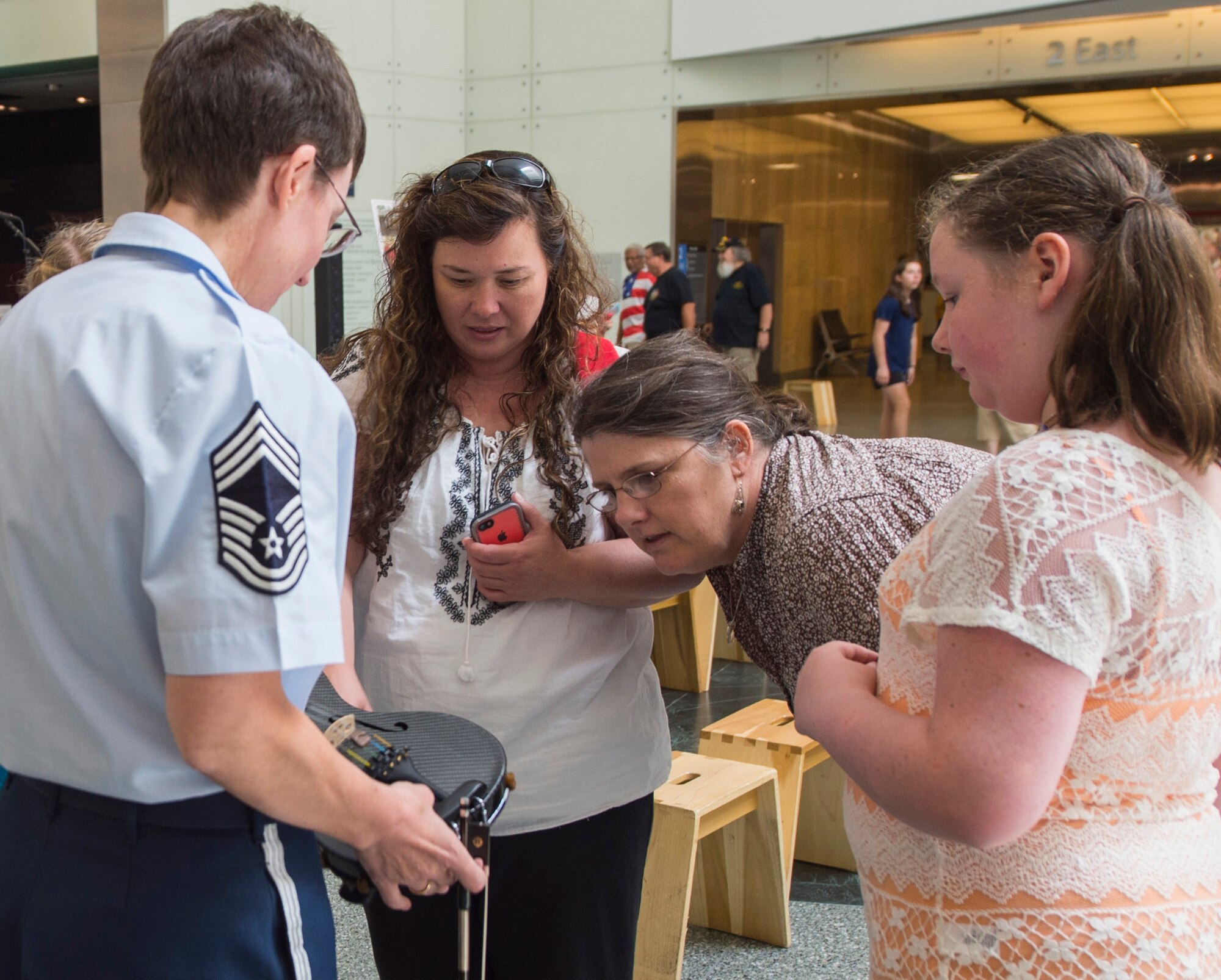 Chief Master Sgt. Deborah Volker, Strolling Strings’ violinist, shows her violin after a performance, to museumgoers at the National Museum of American History in Washington, D.C., July 16, 2015. The U.S. Air Force Band’s Strolling Strings show was part of the museum’s Star-Spangled American Music Series. (U.S. Air Force photo/Airman 1st Class Ryan J. Sonnier)