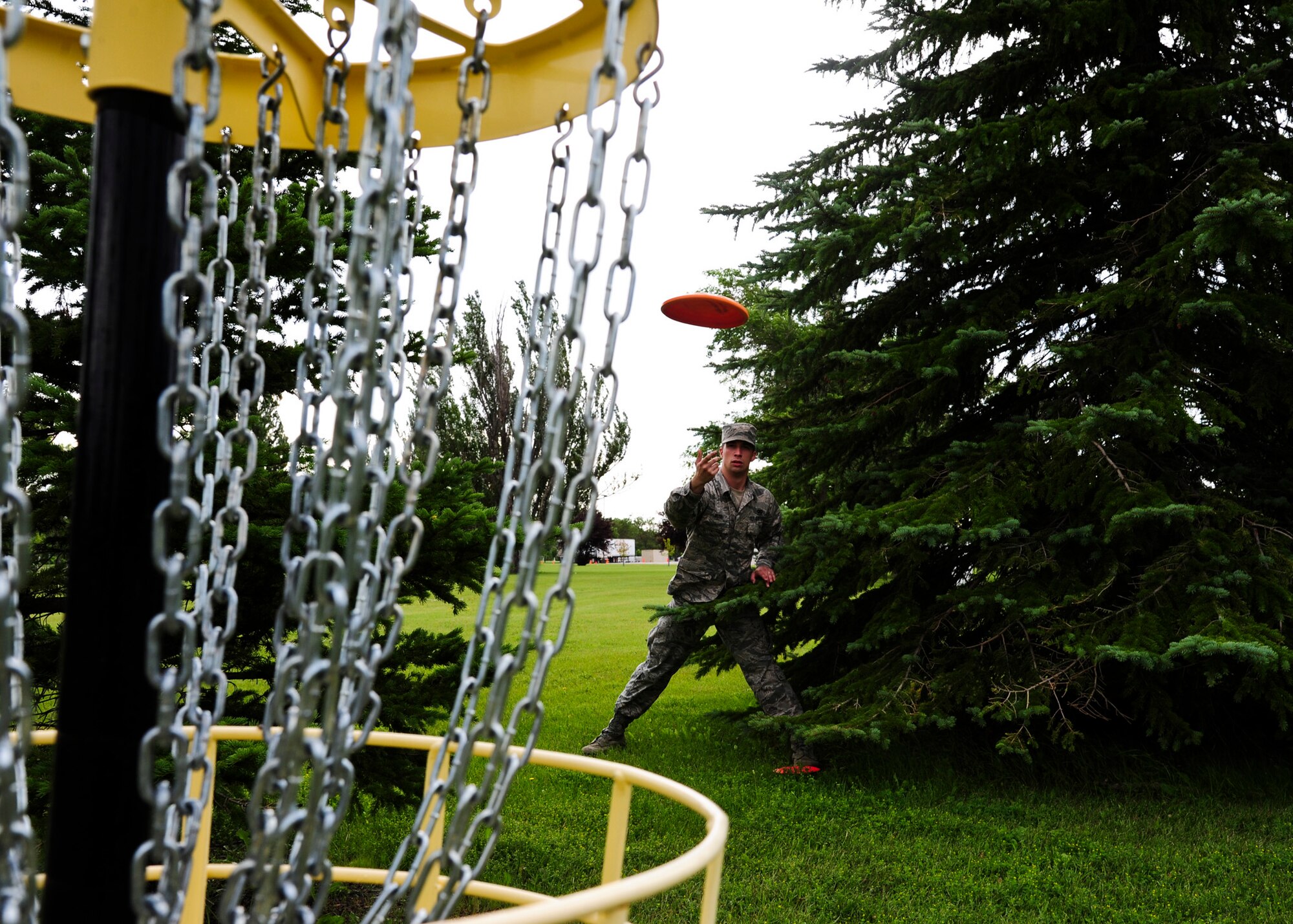 Airman 1st Class Ian Bush, 319th Security Forces Squadron information manager, tosses a disc July 17, 2015 at the Grand Forks Air Force Base disc golf course. Bush has played disc golf for several years. Bush has been organizing events on base in an attempt to make Airmen aware of the disc golf course and its availability to Airmen and their families. (U.S. Air Force photo by Airman 1st Class Ryan Sparks/released)