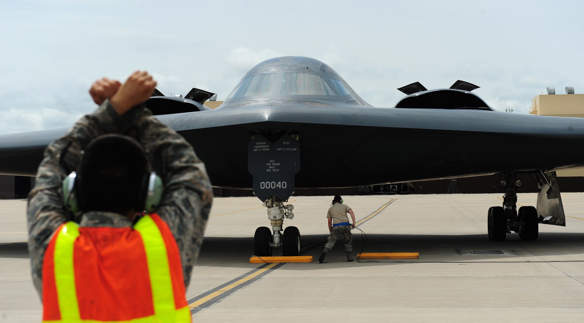 A dedicated crew chief marshals a B-2 Spirit after landing at Whiteman Air Force Base, Mo., July 10, 2015. Three B-2 Spirits flew with an incentive flier and a pilot. The B-2 Spirit incentive flight consisted of a simulated munitions drop as well as an in-flight refueling. (U.S. Air Force photo by Senior Airman Joel Pfiester/Released)