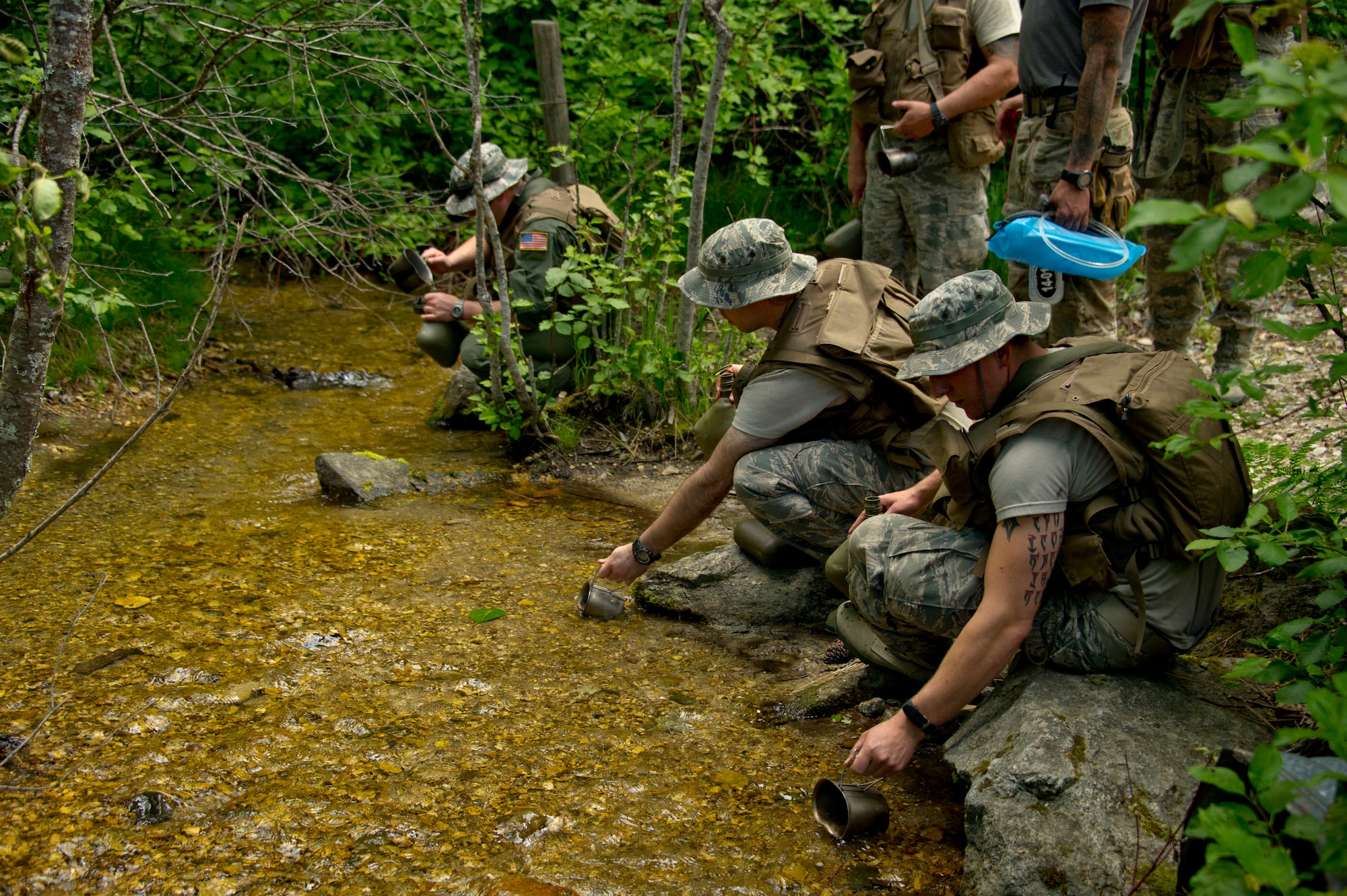 S-V-80-A combat survival students gather water from a stream June 13, 2015, in the Colville National Forest, Wash. To prevent water-borne illness from occurring, the students learned to add iodine tablets or bleach to purify the gathered water. The students also learned that leaving a bottle of water in the sun will result in water purification by the sun’s ultraviolet rays. (U.S. Air Force photo/Airman 1st Class Nicolo J. Daniello)