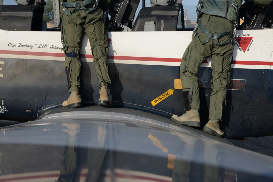 Capt. Robert Brown, left, T-6 Texan II instructor pilot, and 2nd Lt. Bryan Matz, 47th Student Squadron student pilot, conduct an ‘over the rail check’ at Laughlin Air Force Base, Texas, July 14, 2015 The check is the final safeguard to ensure that the aircraft is in proper working order prior to a flight. (U.S. Air Force photo by Airman 1st Class Brandon May)
