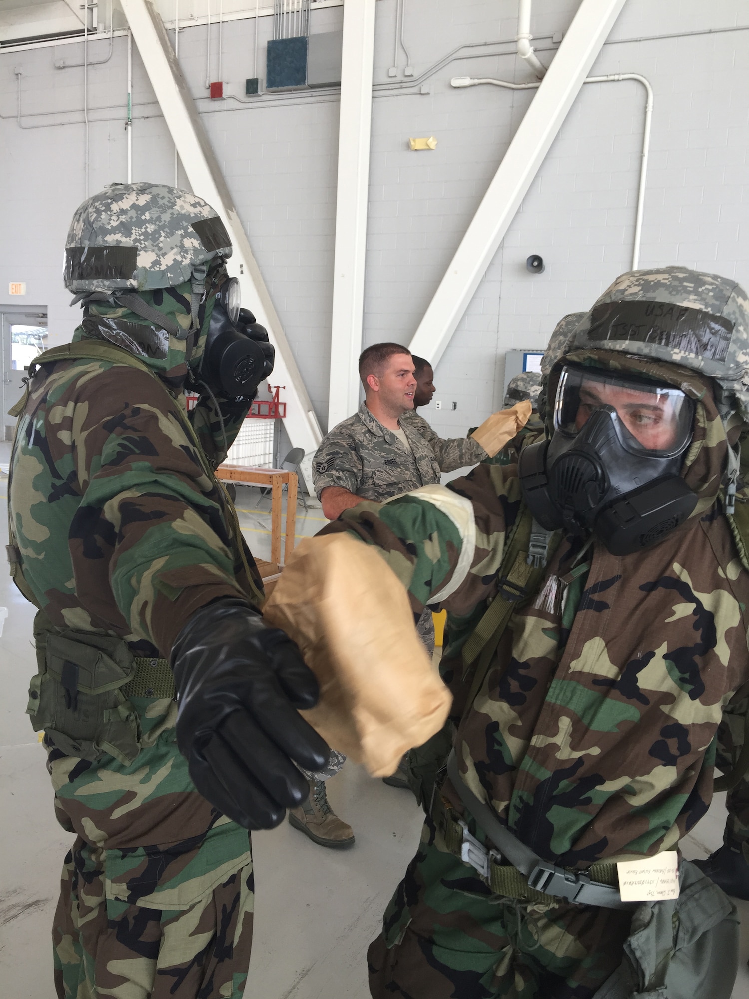 Tech. Sgt. Beau Coleman practices decontaminating Airman 1st Class Lance Goodman's chemical suit as part of a Chemical, Biological, Radiological, Nuclear and Explosives (CBRNE) training class at the Combat Readiness Training Center in Gulfport, Miss. on July 13, 2015.  (U.S. Air National Guard Photo by Capt. Steven Stubbs/Released)