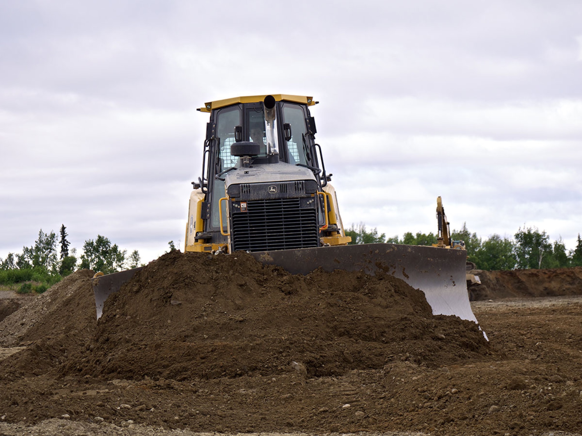 A dozer operated by an 819th Rapid Engineer Deployable Heavy Operational Repair Squadron Engineer (REDHORSE) Airman levels dirt July 7 removed from an approach to the Joint Base Elmendorf-Richardson north-south runway. Airmen of the 819th REDHORSE are deployed to JBER from Malmstrom Air Force Base, Montana. (U.S. Air Force photo/David Bedard)