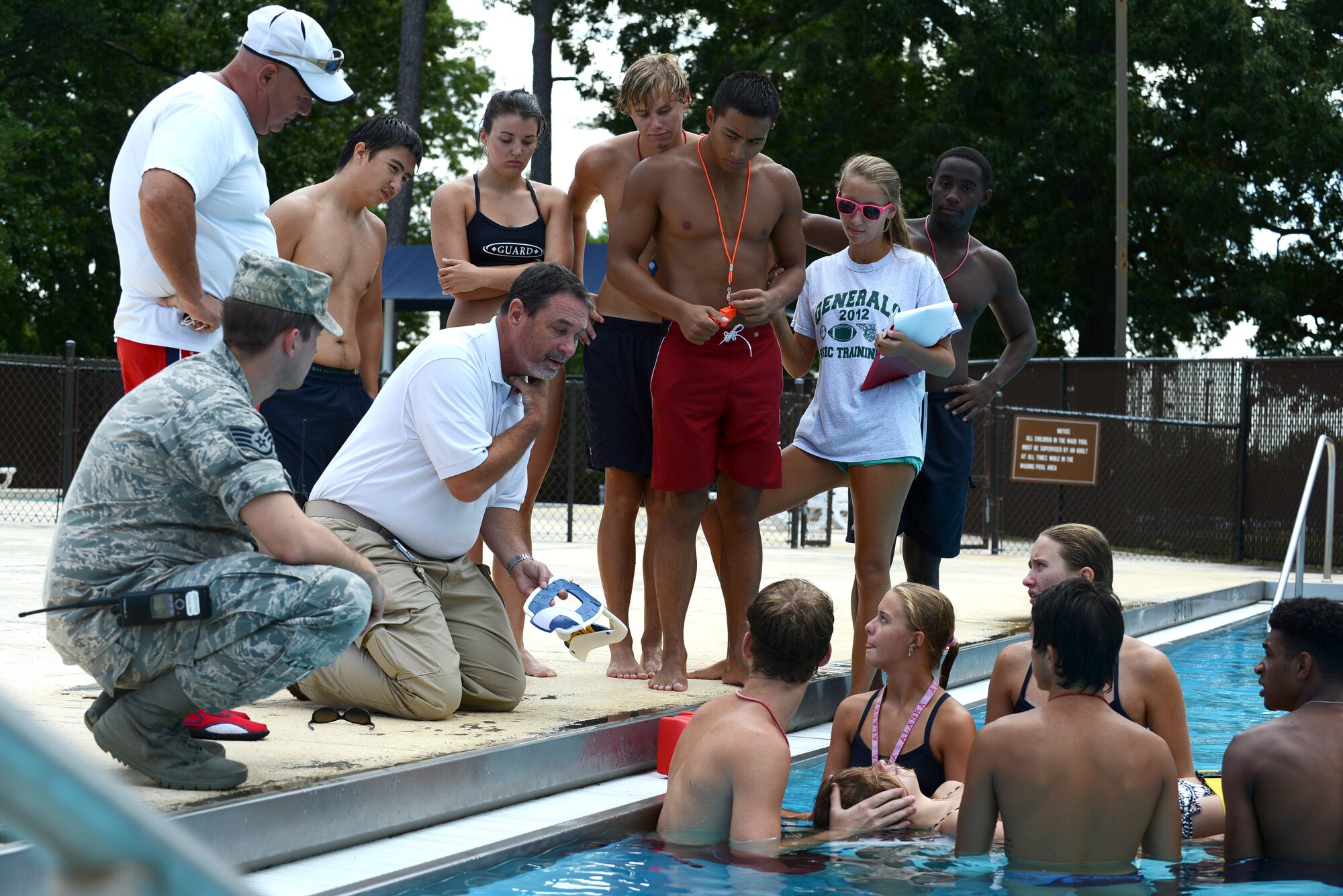 20th Fighter Wing Emergency Medical Technicians teach Team Shaw lifeguards how to fasten a neck brace on a swimmer who suffered a spinal injury during lifeguard training at the Woodland Pool, Shaw Air Force Base, S.C., July 15, 2015. During training sessions, Shaw’s EMTs provide support and assist in the training to ensure fluidity if an emergency situation occurs at the pool. (U.S. Air Force photo by Senior Airman Diana M. Cossaboom/Released)